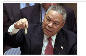 In the UN, Collin Powell holds a model vial of anthrax while arguing that Iraq is likely to possess WMDs
